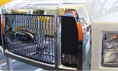 white heavy truck front end with chrome colored grill made from composite materials